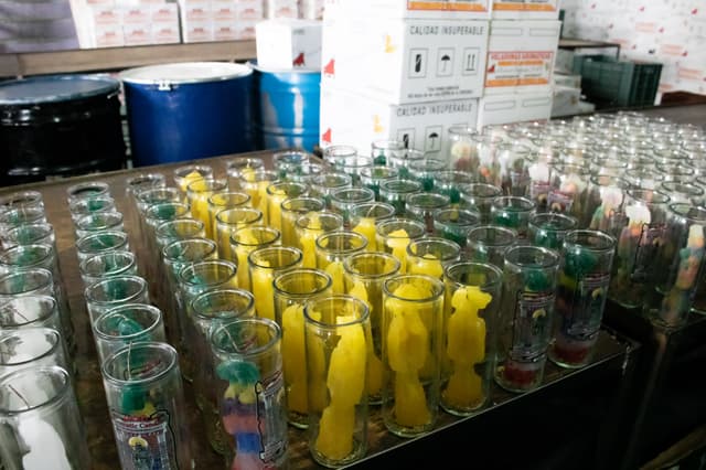 Vasos de veladora de gel con figuras de cera de colores acomodadas a mano