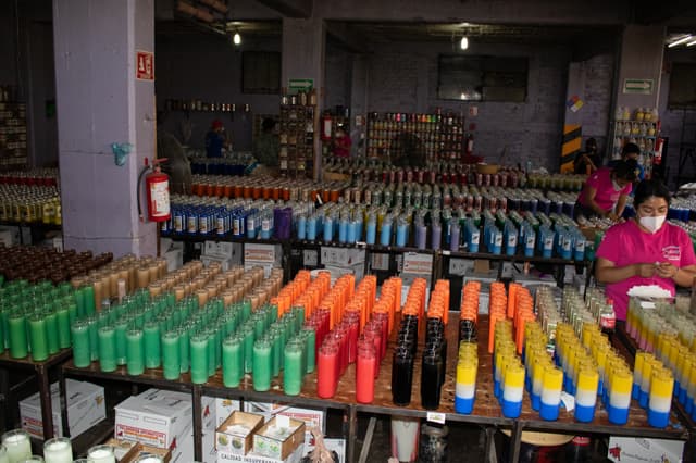 Piso de taller con cientos de veladoras de colores en producción